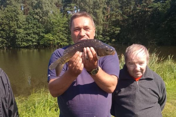 Mieszkaniec trzyma rybę.