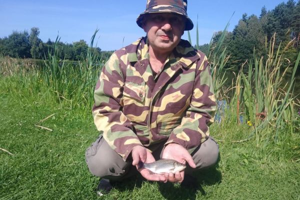 Mieszkaniec trzyma rybę.