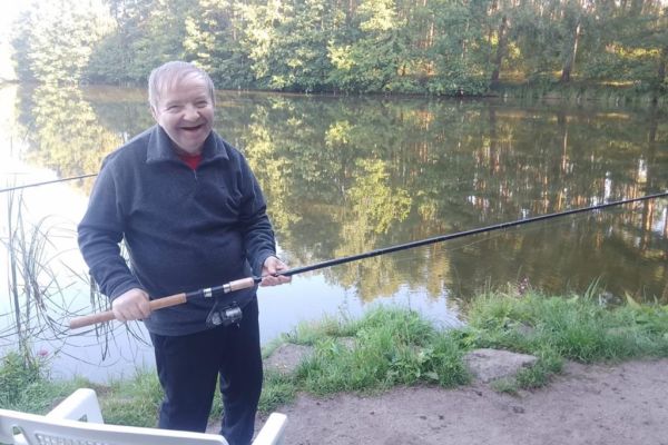 Mieszkaniec trzyma wędkę.