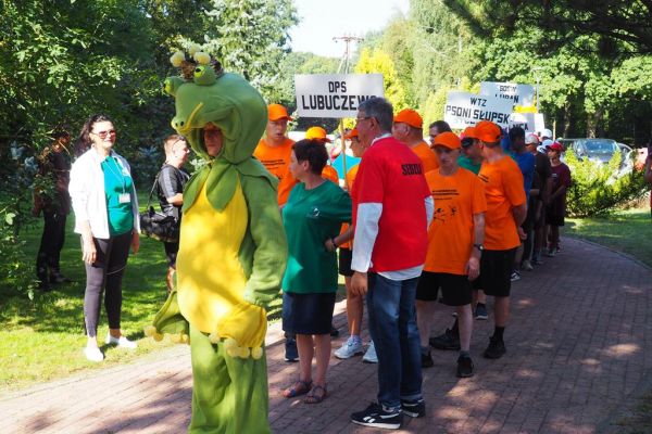 Ustawione drużyny czekające na paradę prowadzoną przez maskotkę żabę.