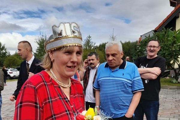 Mieszkanka w koronie wsród innych uczestników festynu.