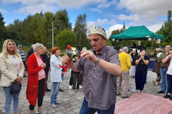 Mieszkaniec w koronie wśród innych uczestników festynu.