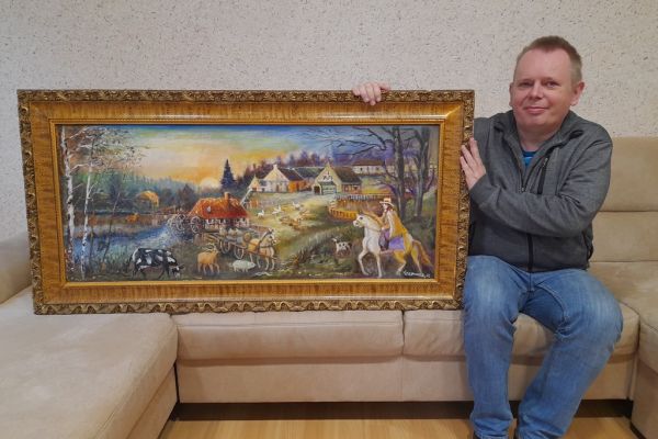Mieszkaniec trzyma obraz.