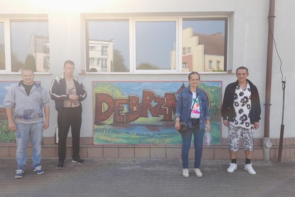 Mieszkańcy stoją przy napisie Debrzno.