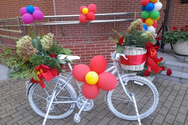 Ustrojony kwiatami biały rower.