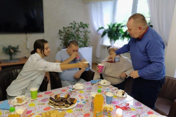 Mieszkaniec polewa szampana innym uczestnikom impezy urodzinowej.