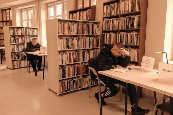 Mieszkaniec czyta w czytelni.