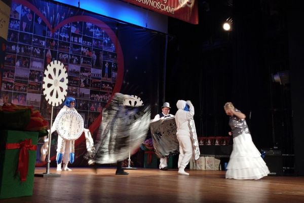 Mieszkańcy występują na scenie w strojach teatralnych.