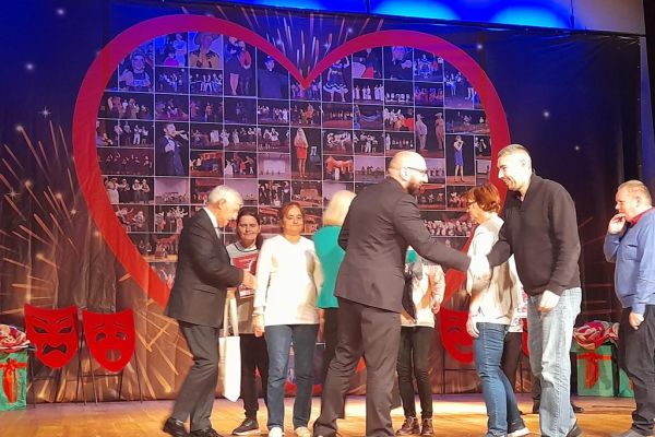 Mieszkańcy na scenie otrzymują podziękowania z rąk władz powiatu.