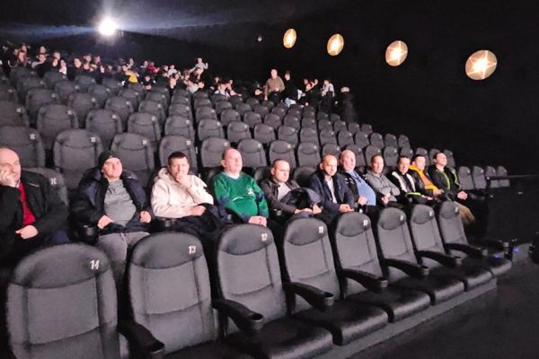 Mieszkańcy siedzą w sali multikina przed seansem.