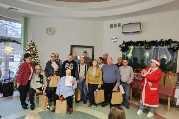 Grupa nagrodzonych mnieszkańców stoi trzymająć podarunki.
