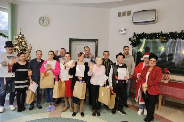 Grupa nagrodzonych mieszkańców stoi trzymająć podarunki.