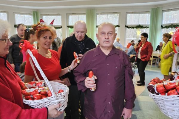 Mieszkaniec otrzymuje czekoladowego mikołaja od pracowników.