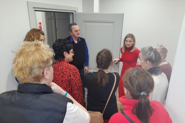 Grupa mieszkańców ogląda pomieszczenia wyremontowanego pałacu.