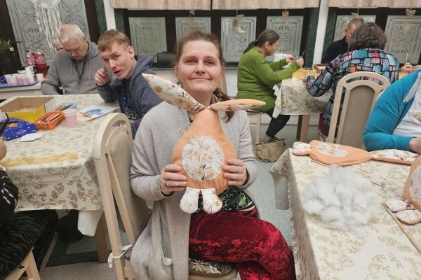 Mieszkanka trzyma uszytego z materiału zająca.