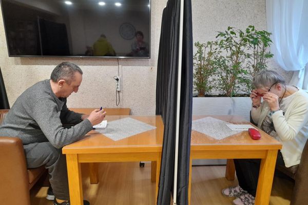 Mieszkańcy głosują przy stoliku.