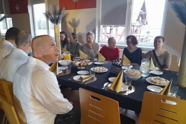 Mieszkańcy siedzą przy suto zastawionym stole na zabawie w Potęgowie.