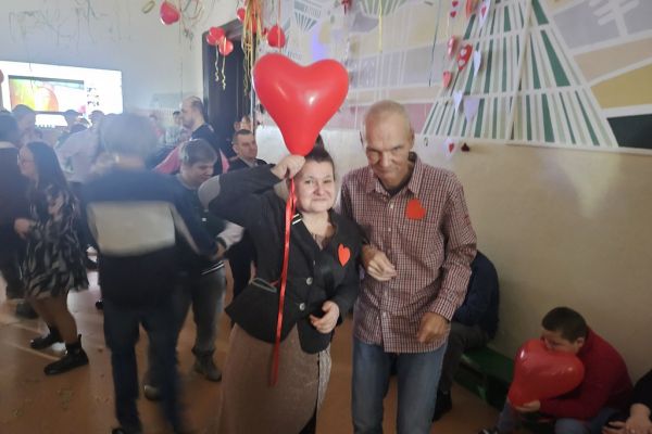 Dwoje mieszkańców z czeronym balonem w kształcie serca.