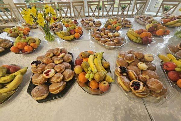 Pączki na tacach i owoce.