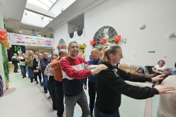 Uczestnicy balu tańczą na cholu tworząc korowód.