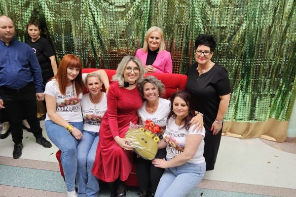 Cztery panie w koszulkach w pączki i trzy panie przedstawicielki władz powiatu.