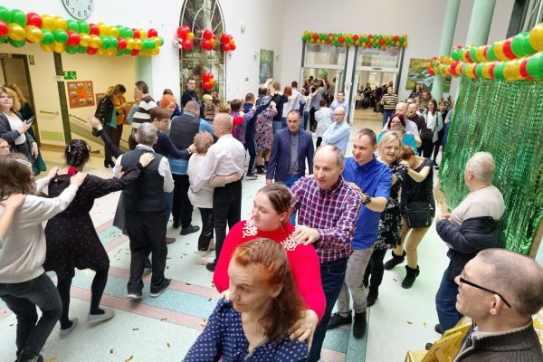 Uczestnicy balu tańczą na holu domu.