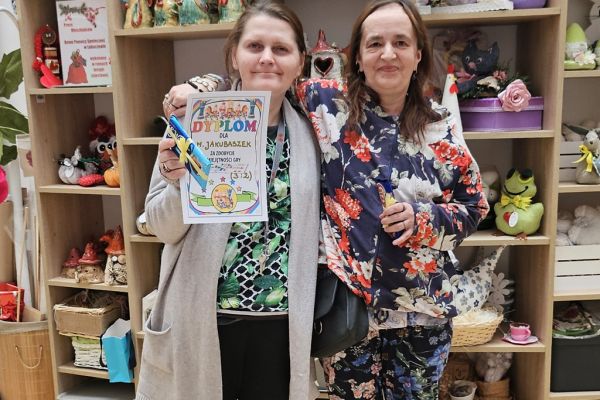 Mieszkanki stoją z dyplomem w ręku.