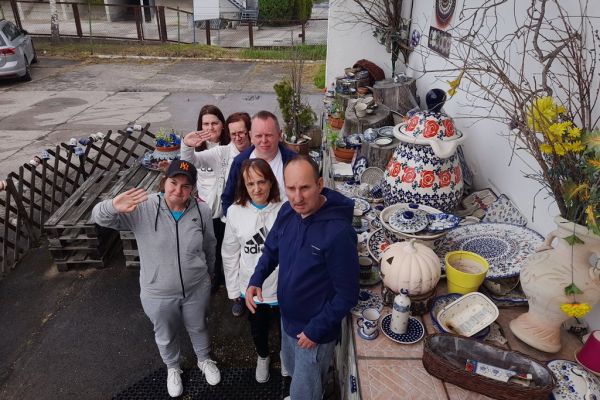 Mieszkańcy stoją grupą przy ozdobnej ceramice z Bolesławca.