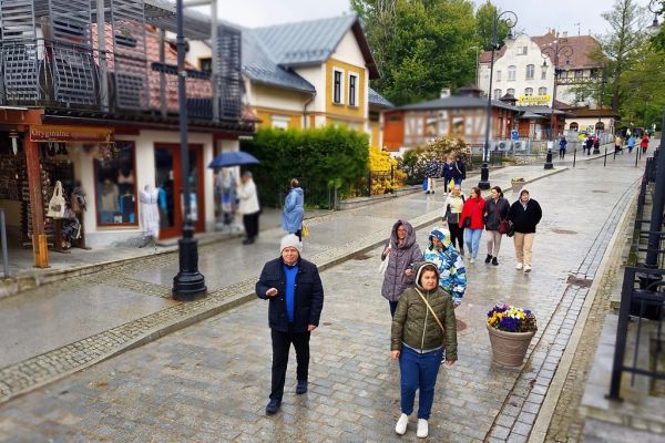 Grupa mieszkańców spaceruje po Świeradowie Zdroju.