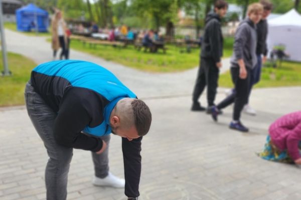 Mieszkaniec rysuje kredą po chodniku.