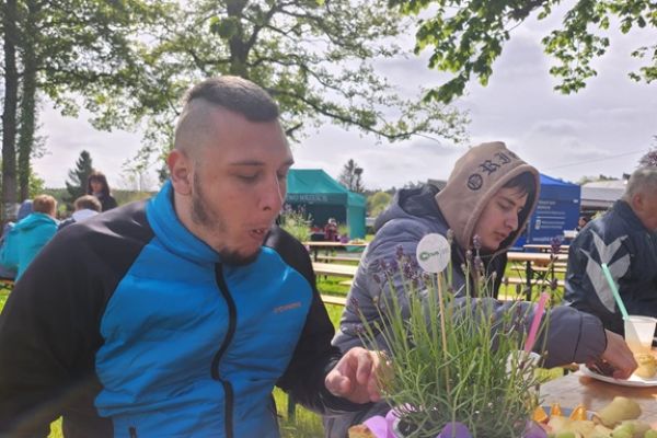 Mieszkańcy jedzą poczęstunek.