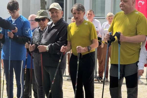 Mieszkańcy wraz z innymi uczestnikami trzymają kijki.