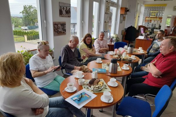 Mieszkańcy siedzą i czytają oraz słuchają tekstów w bibliotece.