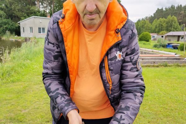 Mieszkaniec trzyma rybę.