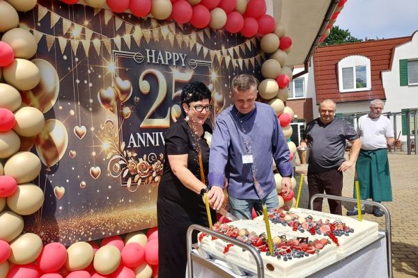 Pani Dyrektor i kucharz kroi tort.