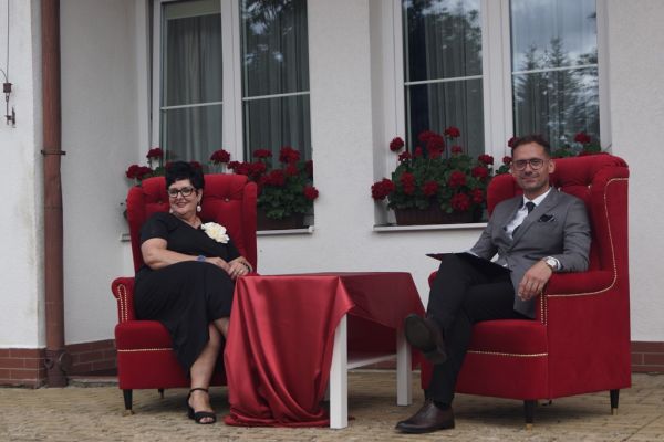 Dyrektor i prowadzący siedzą w czerwonych fotelach