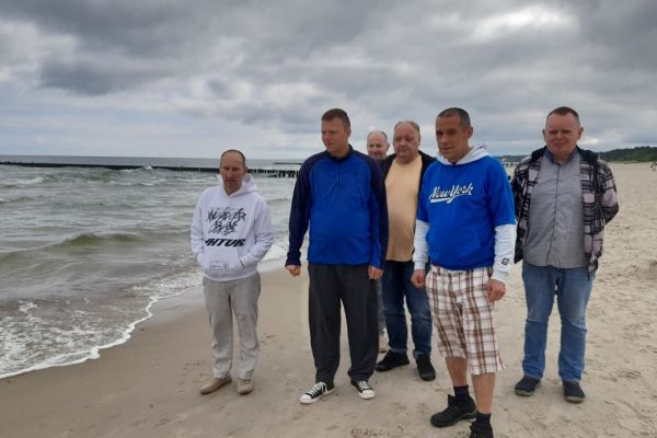 Mieszkańcy stoją nad morzem.