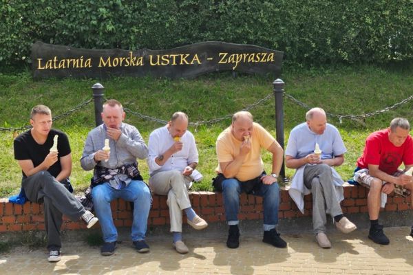 Mieszkańcy siedzą i jedza lody.