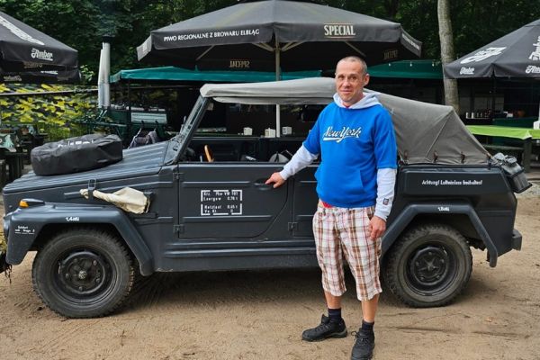 Mieszkaniec przy wojskowym aucie.