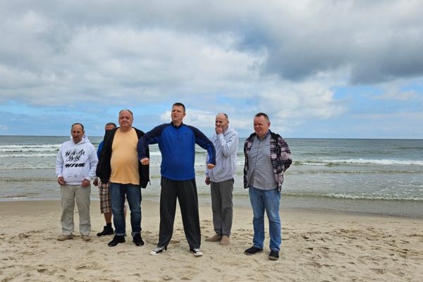 Mieszkańcy stoją nad morzem.