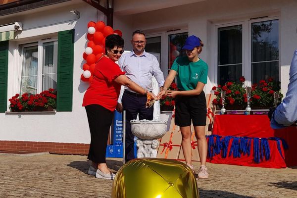 Władze instytucji odpalaja znicz.