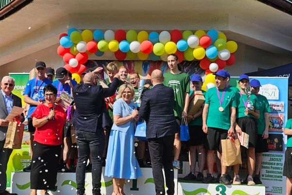 Zwycięzkie drużyny na podium otrzymują gratulacje od władz instytucji.