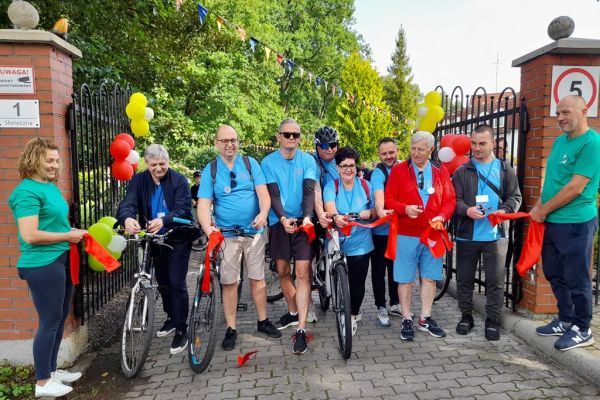 Władze powiatu i instytucji przecinaja wstęgę.