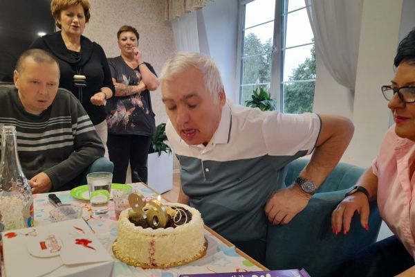Mieszkaniec dmucha świeczki na torcie.