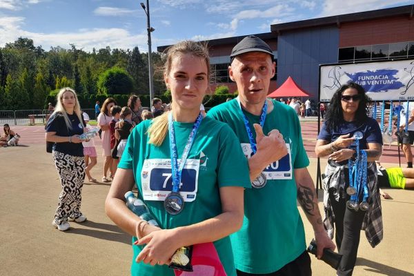 Dwoje mieszkańców z medalami na szyi.