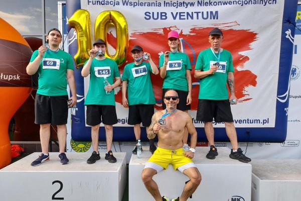 Mieszkańcy wraz z trenerem na podium.