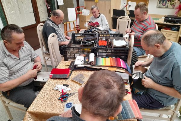 Mieszkańcy wycinają kwadraty z materiałów.