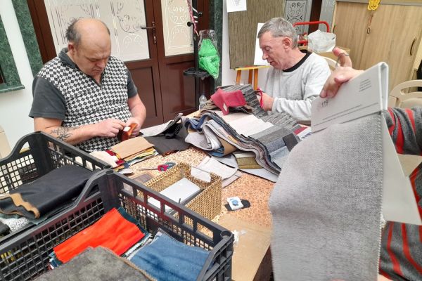 Mieszkańcy wycinają kwadraty z materiałów.