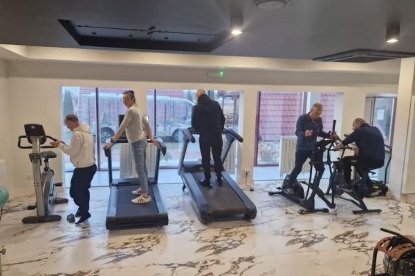 Mieszkańcy ćwiczą na sprzęcie rehabilitacyjnym.